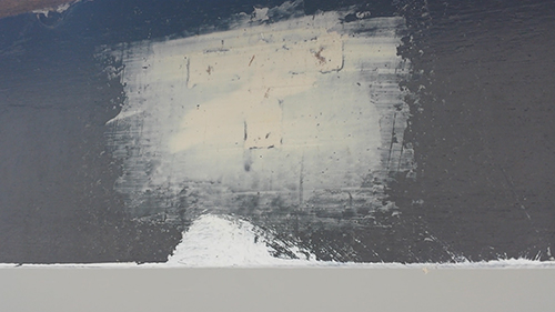 730_pate | 外壁塗装は神奈川県横浜市の塗装職人 Dark wall with a large pale rectangular patch of lighter paint in the center and a white mound at the bottom edge.