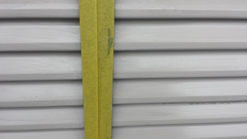 731_amado2 | 外壁塗装は神奈川県横浜市の塗装職人 Yellow strap running vertically across a grey metal shutter.