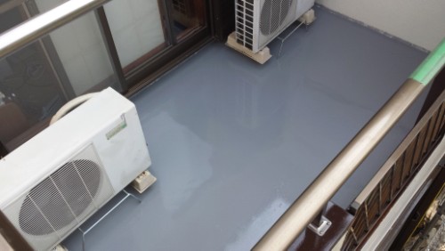 20130810-075525 | 外壁塗装は神奈川県横浜市の塗装職人 Balcony with a glossy gray floor and two outdoor air conditioning units along the wall.