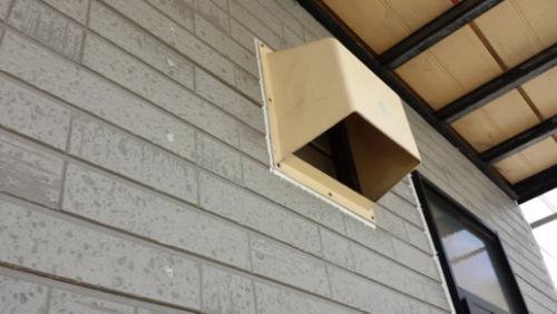 20130828-133544 | 外壁塗装は神奈川県横浜市の塗装職人 Exterior beige exhaust vent protruding from a light gray brick wall under a metal awning.