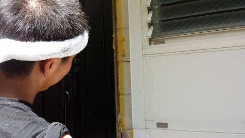 20130831-112758 | 外壁塗装は神奈川県横浜市の塗装職人 Person seen from behind wearing a white headband, facing a doorway next to a windowed wall.