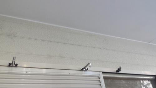 20130831-161123 | 外壁塗装は神奈川県横浜市の塗装職人 Low-angle view of a light-colored ceiling with a metal curtain track and a few roller hooks along the top of a window underneath.