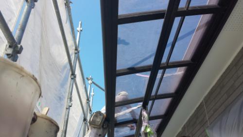 20130902-113112 | 外壁塗装は神奈川県横浜市の塗装職人 Scaffolding along an exterior wall with a glass roof panel over a walkway during construction; blue sky in the background.