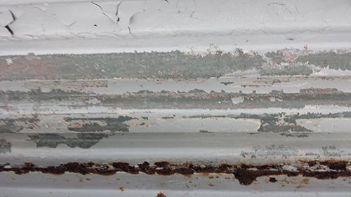 koushin_09hagare1 | 外壁塗装は神奈川県横浜市の塗装職人 Close-up of peeling white paint on a rusty metal surface.