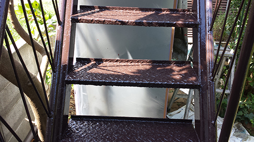 koushin_30tetsu3 | 外壁塗装は神奈川県横浜市の塗装職人 Rusty metal staircase with wet steps and shadows, viewed from below.