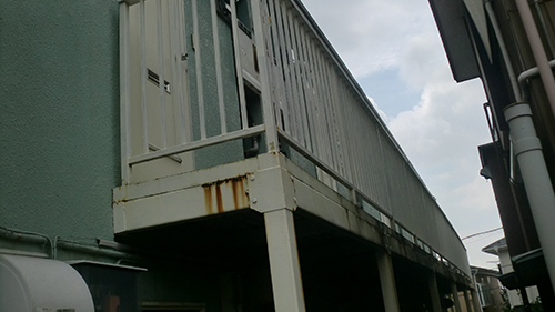koushin_tosoumae1 | 外壁塗装は神奈川県横浜市の塗装職人 Elevated metal walkway and railing along a building, with visible rust stains under the structure.