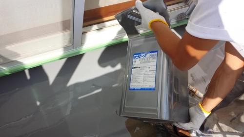 vlcsnap-20130927-11h17m03s | 外壁塗装は神奈川県横浜市の塗装職人 Worker wearing gloves lifts a gray refrigerant canister beside a window frame outdoors