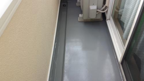 Narrow balcony with a gray floor and an outdoor air conditioner unit near a sliding glass door.