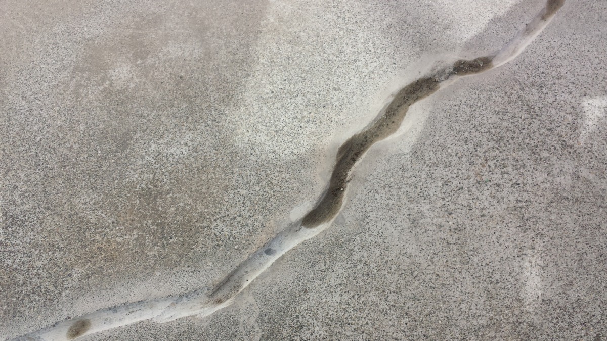 METADATA-START | 外壁塗装は神奈川県横浜市の塗装職人 Aerial view of a pale, meandering crack across a sandy surface