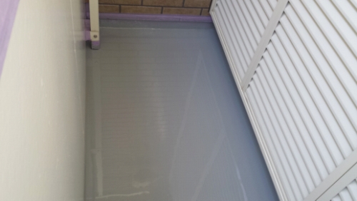 20131202-132356 | 外壁塗装は神奈川県横浜市の塗装職人 Narrow, flooded passage between a pale wall and white louvered shutters, with gray water covering the floor.