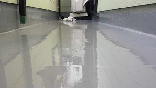 koushin_18uretan | 外壁塗装は神奈川県横浜市の塗装職人 Wet concrete alley with pooled water and reflections, leading to a white bag at the far end.