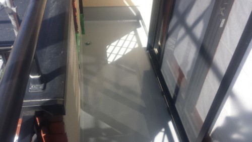 koushin_20140306-101446-1 | 外壁塗装は神奈川県横浜市の塗装職人 Narrow outdoor balcony with glass doors and metal railing, sunlight casting geometric shadows on a pale floor.