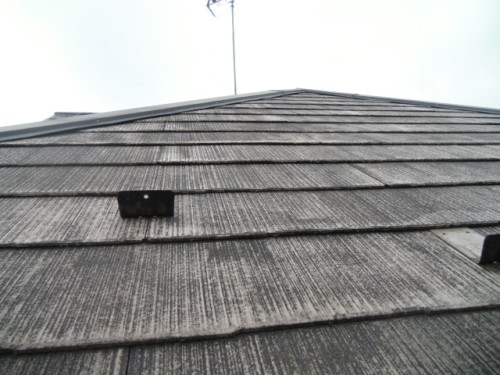 koushin_CIMG1154-1 | 外壁塗装は神奈川県横浜市の塗装職人 Low-angle view of a gray, weathered asphalt shingle roof with a TV antenna at the peak.