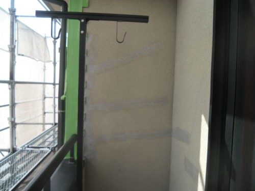 koushin_CIMG1202-1 | 外壁塗装は神奈川県横浜市の塗装職人 Narrow balcony with a metal hook on a horizontal bar, green support beam, and scaffolding visible on the left side.