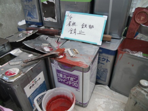 koushin_CIMG1207-1 | 外壁塗装は神奈川県横浜市の塗装職人 Cluttered workshop bench with metal paint cans, tools, and a handwritten Japanese sign on a metal surface.