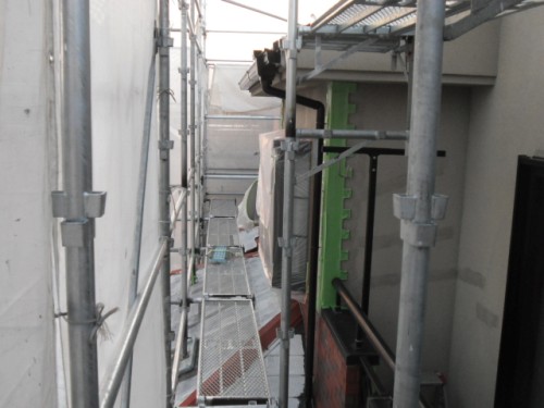 koushin_CIMG1215-1 | 外壁塗装は神奈川県横浜市の塗装職人 Narrow construction scaffold along a building exterior with metal planks and safety rails viewable from above.