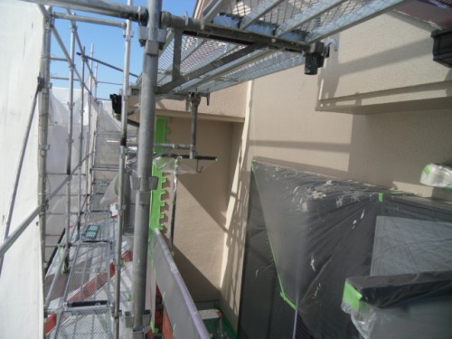 koushin_CIMG1239-1 | 外壁塗装は神奈川県横浜市の塗装職人 Construction scaffolding along the exterior of a building under renovation, with plastic-covered equipment nearby.