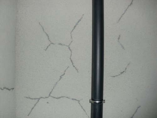 koushin_CIMG5118-1 | 外壁塗装は神奈川県横浜市の塗装職人 Cracked light-gray wall with a vertical dark pipe running down the center.
