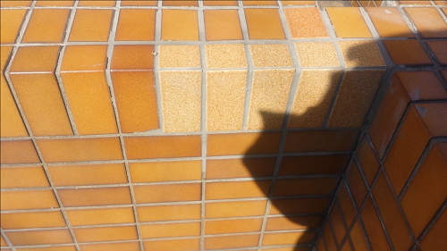 koushin_tile-hoshu | 外壁塗装は神奈川県横浜市の塗装職人 Orange tiled stair steps in bright sun with a large shadow cast across the surface.
