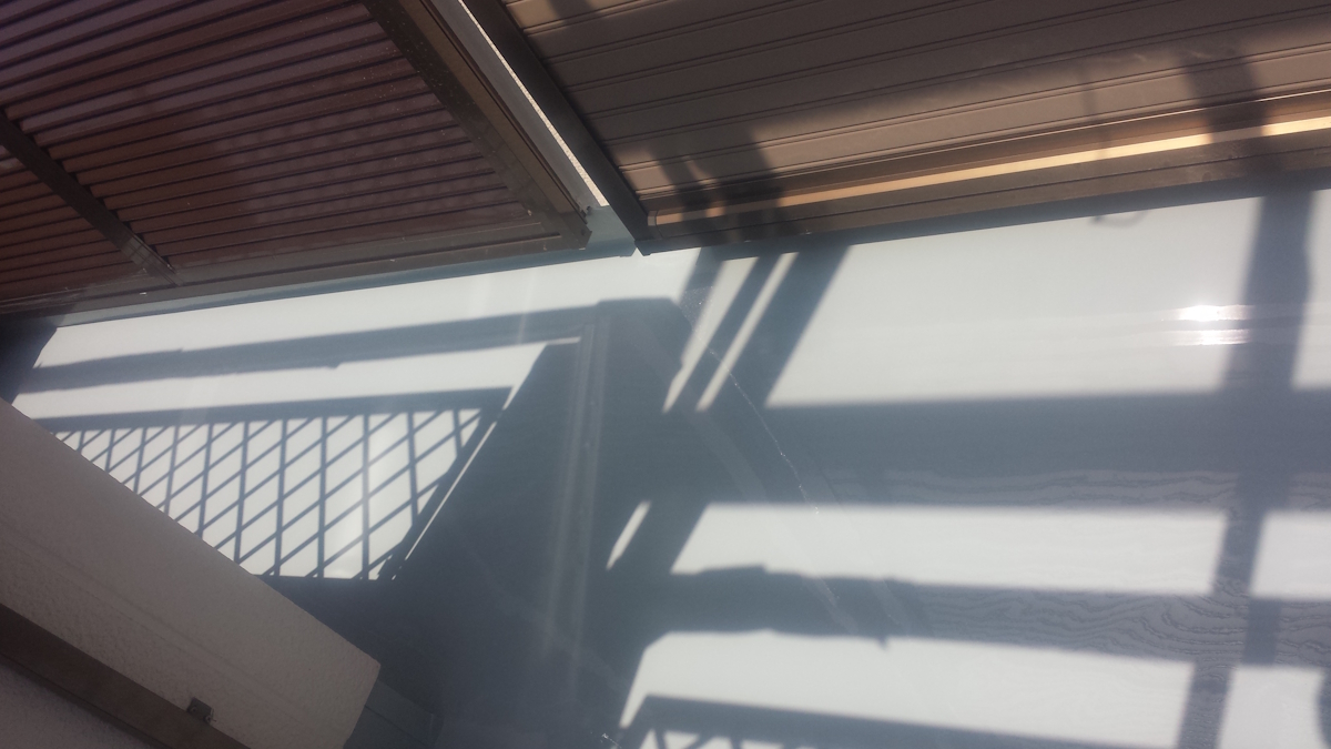 METADATA-START | 外壁塗装は神奈川県横浜市の塗装職人 Sunlight casts angular shadows of a railing and window blinds across a pale floor surface in a bright indoor space.