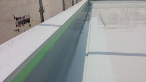 20140416-093950-1 | 外壁塗装は神奈川県横浜市の塗装職人 Narrow rooftop pool or water trough with a white edge and a green seam, filled with calm water reflecting the surrounding area.
