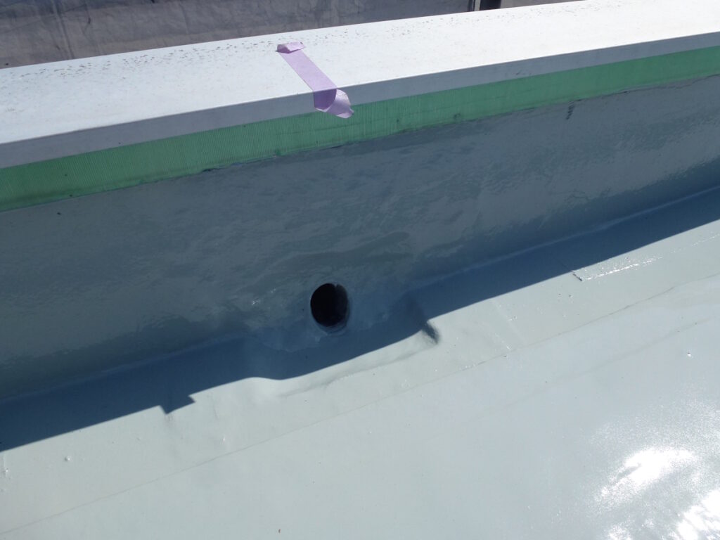 P1030200 | 外壁塗装は神奈川県横浜市の塗装職人 Close-up of a pool wall with a circular drain hole and pink tape along the edge.
