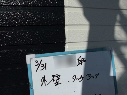 Whiteboard with handwritten notes (date 3/31) on a blue frame, propped against a black and white wall; a large shadow of a person covers part of it.