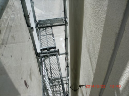 CIMG0379 | 外壁塗装は神奈川県横浜市の塗装職人 Narrow gap between concrete walls showing metal scaffolding platforms and guardrails in use for construction.