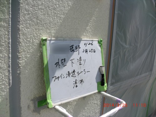 CIMG0384 | 外壁塗装は神奈川県横浜市の塗装職人 Whiteboard with handwritten Japanese notes taped to an exterior wall during renovation, green painter's tape securing it near a window; timestamp 2014/3/25 11:10 visible in red at bottom right.