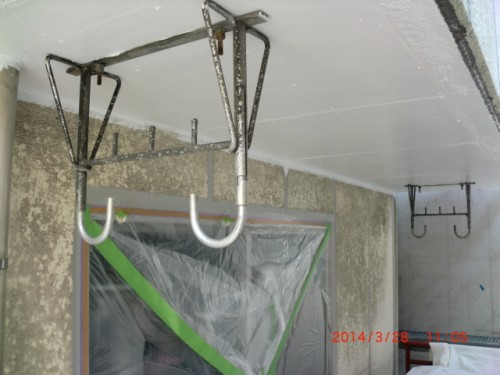 CIMG0394 | 外壁塗装は神奈川県横浜市の塗装職人 Indoor construction area with metal rings hanging from ceiling brackets, plastic sheeting covering a doorway.