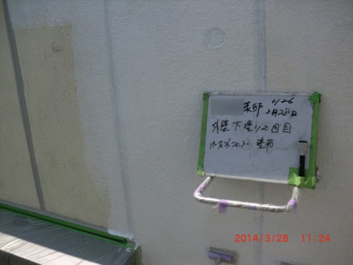 CIMG0395 | 外壁塗装は神奈川県横浜市の塗装職人 Whiteboard with handwritten Japanese text taped to a beige wall with green tape and a purple pipe nearby; orange timestamp 2014/3/28 11:24 visible.