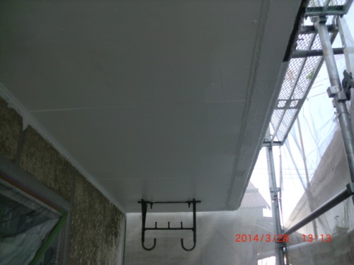 CIMG0399 | 外壁塗装は神奈川県横浜市の塗装職人 Underside of a balcony with scaffolding to the right and a metal hanging hook bracket underneath the overhang.