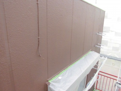 CIMG1394 | 外壁塗装は神奈川県横浜市の塗装職人 Brown stucco exterior wall with scaffolding and plastic sheeting masking the lower edge for painting.