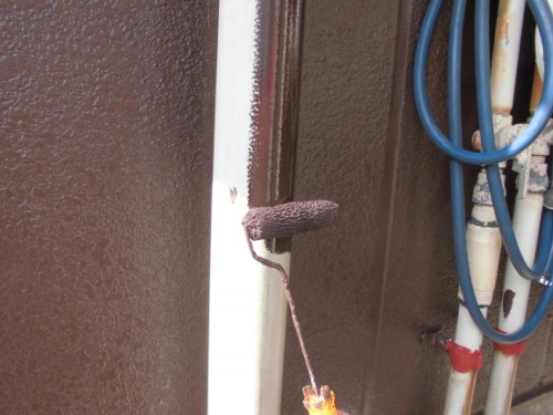 CIMG1433 | 外壁塗装は神奈川県横浜市の塗装職人 Close-up of a rusty latch on a white metal post with blue hoses in the background.