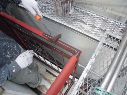 CIMG1443 | 外壁塗装は神奈川県横浜市の塗装職人 Worker wearing gloves paints a red metal handrail on a scaffold.