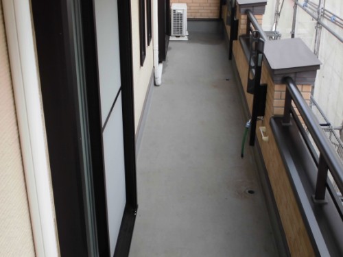 Narrow apartment balcony with sliding doors on the left and a railing on the right, an outdoor unit at the far end.