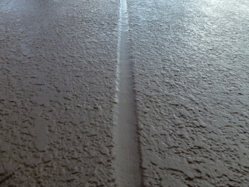 koushin_P1030163-1 | 外壁塗装は神奈川県横浜市の塗装職人 Close-up of wet sand with a narrow central groove dividing textured surfaces on either side.