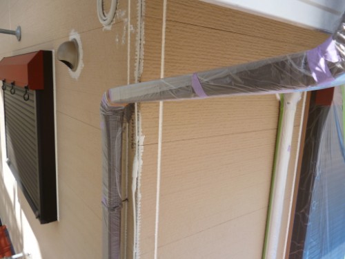 Exterior wall with insulated pipes and ducts wrapped in plastic during renovation/installation.