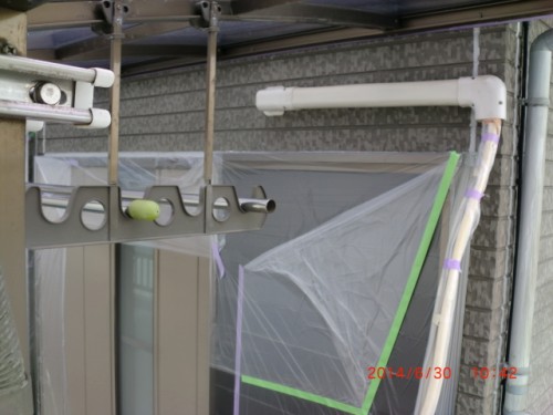 Close-up of a construction scaffold canopy with PVC pipes and a plastic drop cloth taped to a window area.