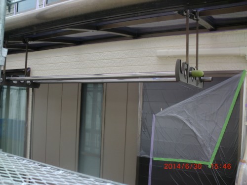 Scaffolding and protective plastic cover on a building exterior, with green tape securing a barrier; timestamp visible 2014/6/30 15:46.