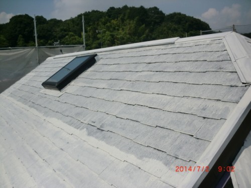White sloped roof with a dark skylight window, outdoors with trees in the background and a red timestamp on the lower-right corner reading 2014/07/12 9:02