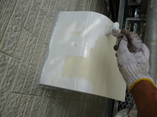 koushin_P1050834-1 | 外壁塗装は神奈川県横浜市の塗装職人 Person wearing gloves painting a white metal utility box mounted on an exterior brick wall with a brush