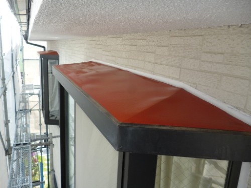 koushin_P1050835-1 | 外壁塗装は神奈川県横浜市の塗装職人 Orange metal awning over a window on an exterior wall with scaffolding along the left side of a building under construction.