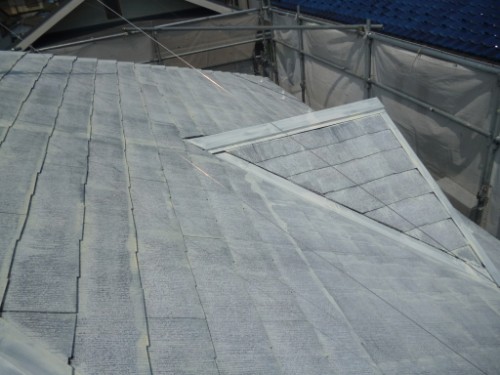koushin_P1050847-1 | 外壁塗装は神奈川県横浜市の塗装職人 Close-up of a gray slate roof under construction with scaffolding in the background.