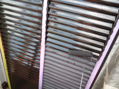 koushin_P1050901-1 | 外壁塗装は神奈川県横浜市の塗装職人 Close-up of horizontal window blinds being painted with a roller; purple insulation foam around the frame.