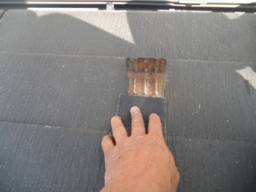 koushin_CIMG2579-1 | 外壁塗装は神奈川県横浜市の塗装職人 Close-up of a hand with a small brush applying sealant to a dark roof shingle.