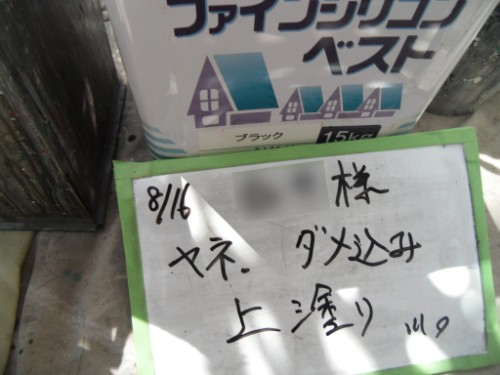 koushin_CIMG2662 | 外壁塗装は神奈川県横浜市の塗装職人 Whiteboard with handwritten Japanese notes (date 8/16) leaning on a green frame next to a white container labeled 15kg with a blue-house graphic; sunlight casts a shadow on the scene.