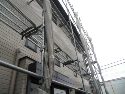 koushin_CIMG2665 | 外壁塗装は神奈川県横浜市の塗装職人 Exterior of a brick building under construction with metal scaffolding along the facade of the building.