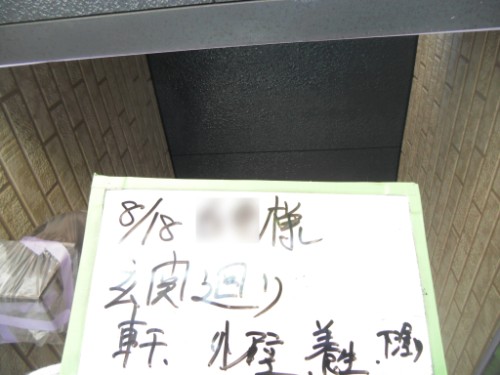 koushin_CIMG2669 | 外壁塗装は神奈川県横浜市の塗装職人 Handwritten Japanese note on a white board with a light-green border resting on a ledge in a brick entryway.