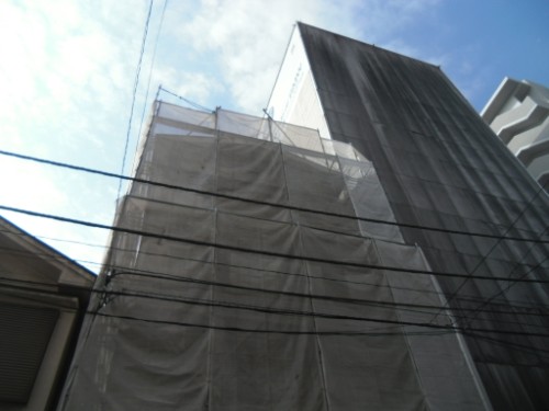 koushin_CIMG2870-1 | 外壁塗装は神奈川県横浜市の塗装職人 Building under construction with scaffolding and protective netting along its facade.